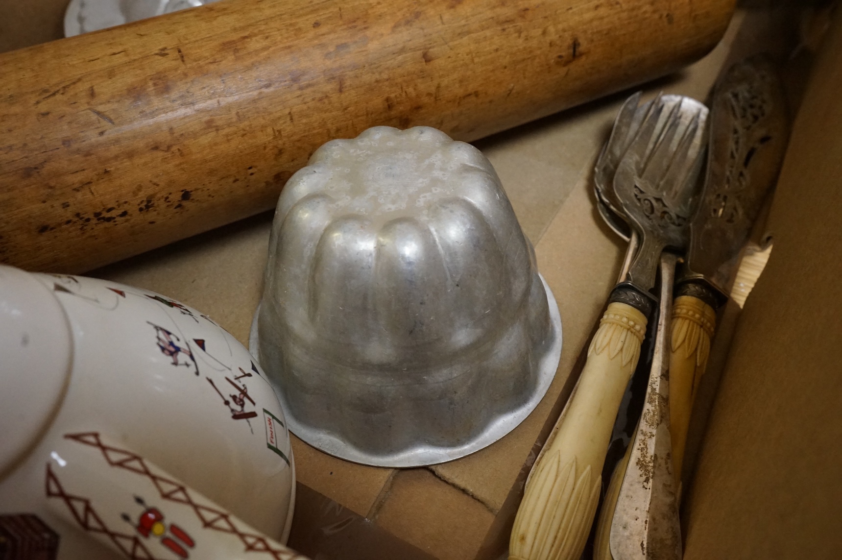 A collection of Kitchenalia, including a Wade novelty teapot, a large wooden rolling pin, jelly moulds, etc.